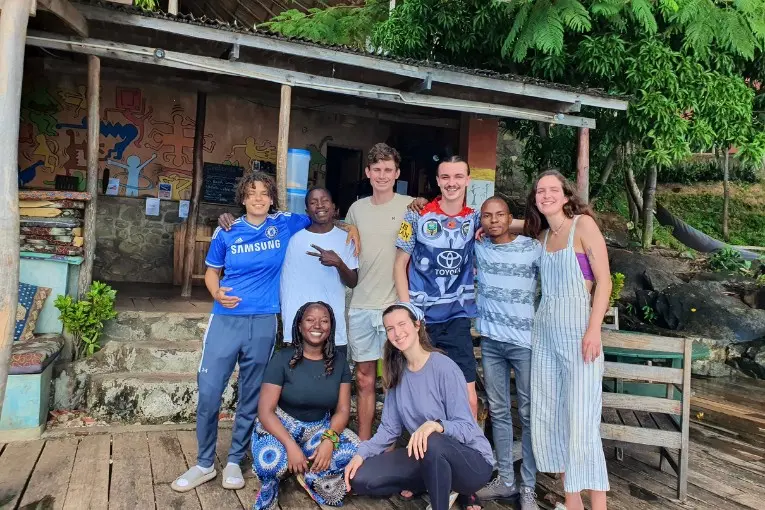 interns with locals by a house