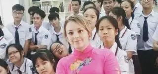 ITA teacher sitting on the floor with her students