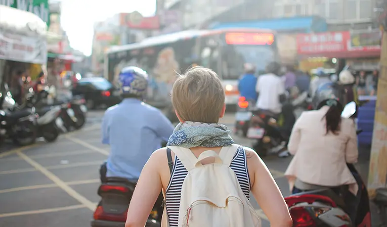 Girl walking through a busy street in Asia