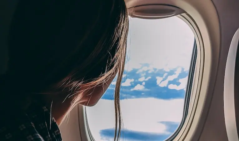 person looking out airplane window