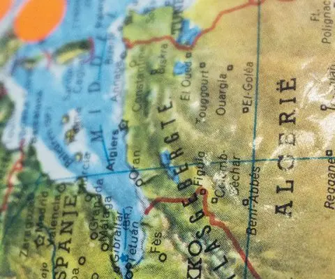 close up of globe with orange stickers on locations