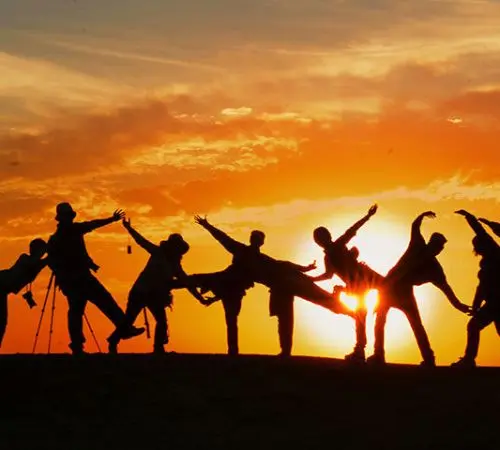 group of travel friends taking picture at sunset