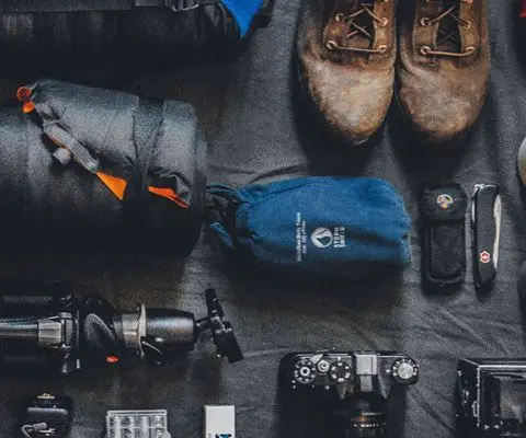 flat lay photo of backpacking and photography gear
