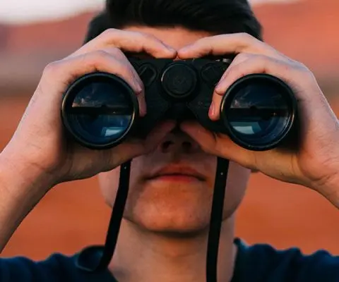 man looking through a telescope