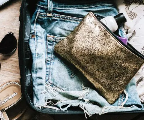 laptop and camera sitting outside open suitcase