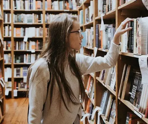 student searching for books in the library