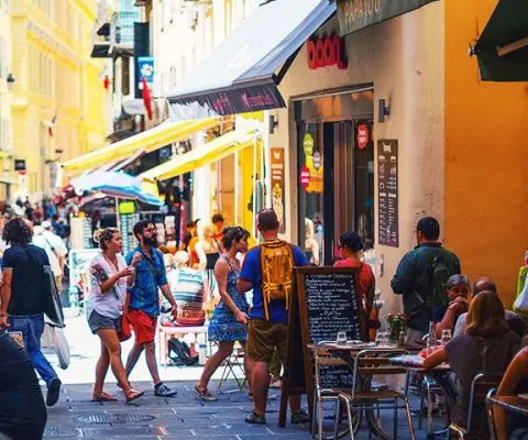 people walking down a street in nice, france