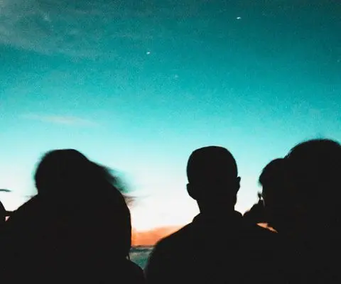 silhouette group of students on beach at sunset