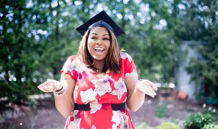 Smiling study abroad student wearing a graduation cap.