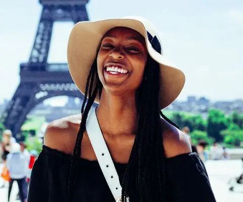 Girl smiling in front of the Eiffel Tower
