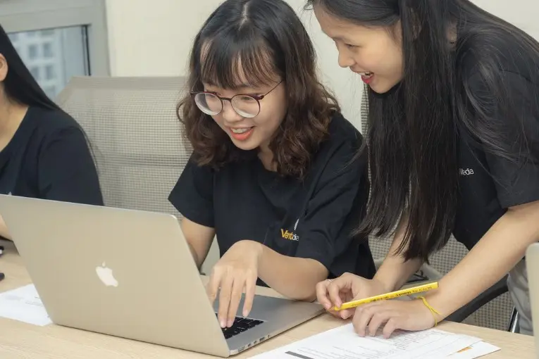 two women using a laptop
