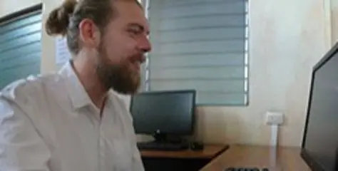 photo of a man sitting in front of a computer
