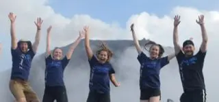 ITA teacher sitting on the floor with her students