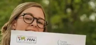 a girl holding her ITA TEFL Certificate