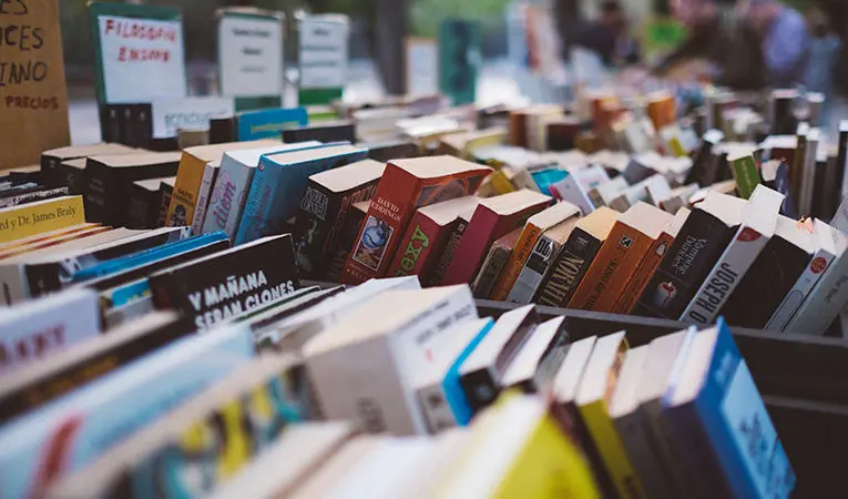 close up of books organized in market bins for sale