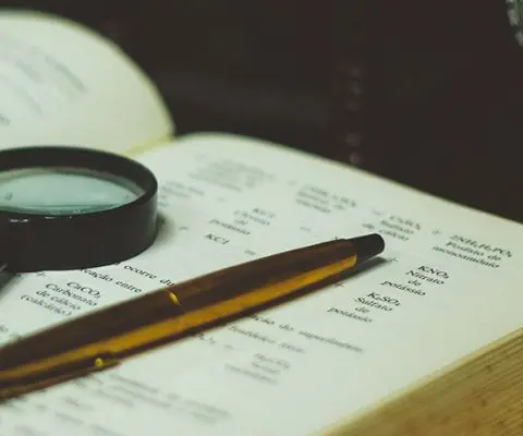 Closeup of a book and magnifying glass on an office desk