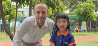 ITA teacher sitting on the floor with her students