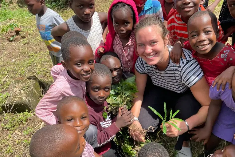 person planting while surrounded by local kids