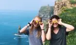 Two girls standing on edge of a cliff with yellow flowers on eyes 